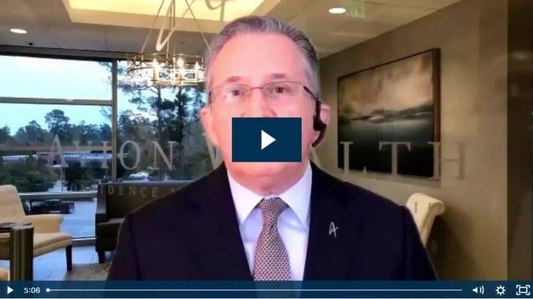 Man in office suit speaking with headset in modern office setting.