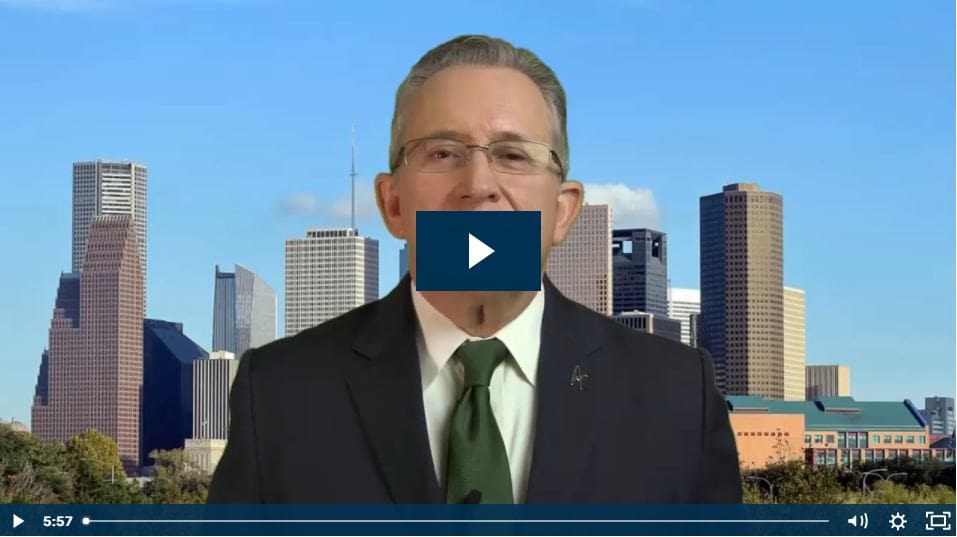 Man in suit speaking with city skyline in background.