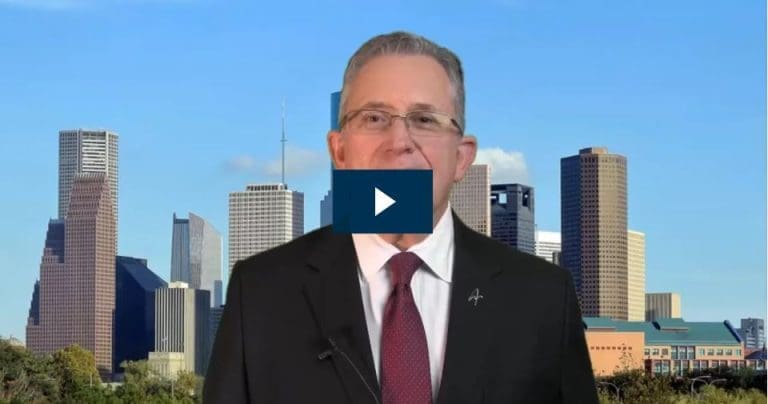 Man speaking with a city skyline background.