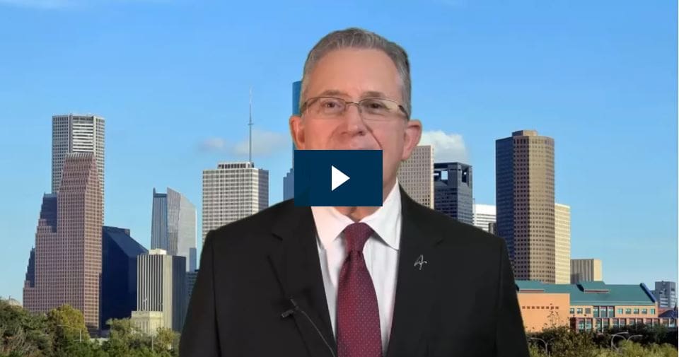 Man speaking with a city skyline background.