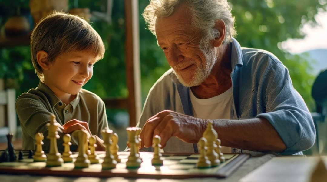 Adapting to life after selling your business, represented by image of grandfather playing chess with grandson.