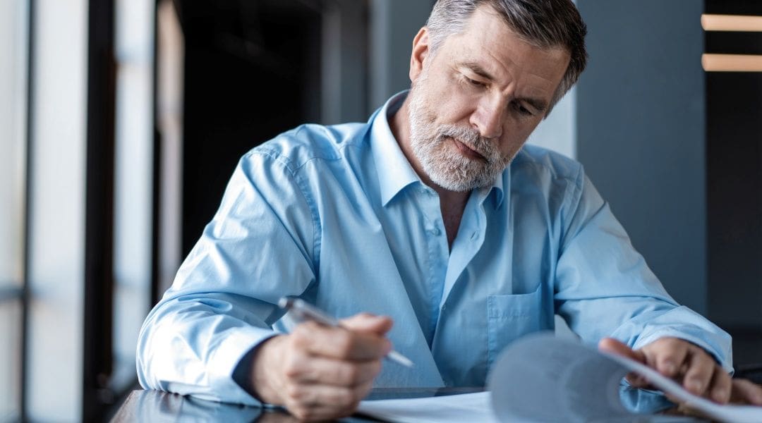 Planning to sell your business, represented by image of business man reviewing a document