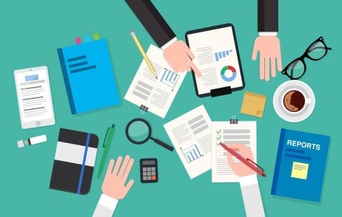 Tax considerations when selling a business, represented by illustration of desktop with documents, pencils, eye glasses on it.