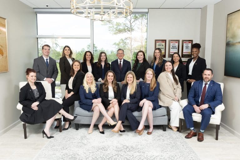 A professional team posing in an office setting.
