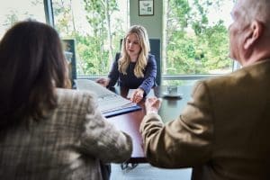 Meeting with businesswoman presenting documents at a table.