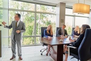 Business meeting with a presentation in a glass-walled conference room.