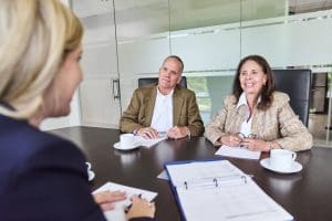 Meeting with three professionals in a conference room, discussing business strategy.
